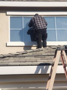 Ben on a roof installation a dual pane window